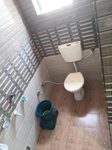 a bathroom with a toilet and a bucket in it at Hotel shivalay in Dwarka