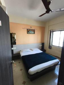 a bedroom with a large bed with a blue blanket at Hotel shivalay in Dwarka