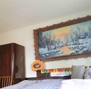 a painting of a winter scene on the wall of a bedroom at RETREAT MOUNTAIN CASA TRADIȚIONALĂ,Roşia Montana in Roşia Montană