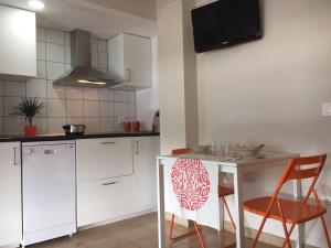 a kitchen with white cabinets and a table and chairs at Apartamento Apolo in Platja d'Aro