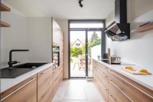 a kitchen with wooden cabinets and a view of a patio at Traumhafte Architekten-Doppelhaushälfte in Unterschleißheim