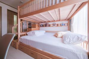 een slaapkamer met een stapelbed met witte kussens bij TDR9分 駄菓子とアートの可愛いミュージアム宿 夢が詰まった小さな宝箱 -TAMU-LAND Urayasu- in Urayasu