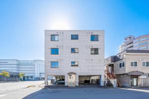 a tall building with a car parked in front of it at Silk Court 201 in Chitose +74 photos