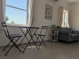 a living room with a table and two chairs and a couch at River and Mountains in HaGoshrim