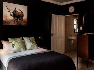 - une chambre avec un lit avec une vache sur le mur dans l'établissement Hillcrest Hosting AirBnB, à Kimberley 6 autres photos