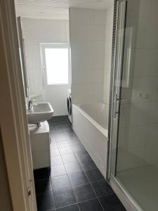 Un baño con bañera, lavabo y ducha. en Provence Driehuis Apartment, en Driehuis