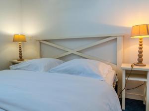 a bedroom with a white bed with two lamps at D de Bertheaume N413 2P5 in Plougonvelin +7 photos