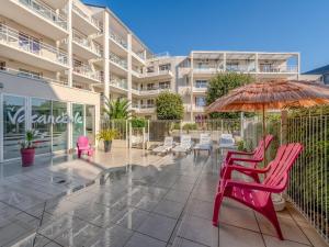 a patio with chairs and umbrellas in front of a building at D de Bertheaume N413 2P5 in Plougonvelin