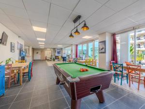 a pool table in a room with tables and chairs at D de Bertheaume N413 2P5 in Plougonvelin