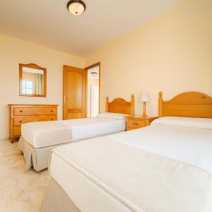 a bedroom with two beds and a mirror at Be six Playa La Arena in Puerto de Santiago +21 photos