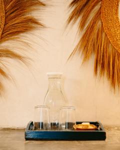 a tray with two glasses and a large vase at Kholle Villa in Jambiani