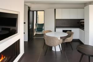 a dining room with a table and chairs and a fireplace at White and Black Cozy Suite in Aegina in Áyioi Asómatoi +19 photos