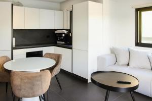 a small living room with a table and a couch at White and Black Cozy Suite in Aegina in Áyioi Asómatoi