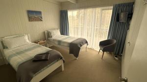 a hotel room with two beds and a window at One95 Family Beach House in Anglesea