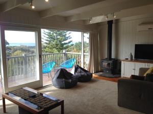 a living room with a fireplace and a balcony at One95 Family Beach House in Anglesea
