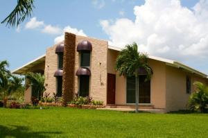 a building with palm trees in front of it at Punta Chame Club and Resort in Chame