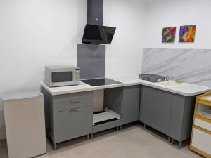 a kitchen with a white counter and a microwave at Self-contained basement appartement close to Disneyland & Vallée Village outlet in Pommeuse +3 photos