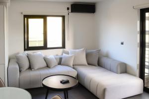 a living room with a couch and a table at White & Black Aegina - Private Garden & Parking in Áyioi Asómatoi