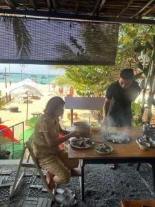 a man and a woman preparing food at a table at SOHO 1 PHÚ QUỐC in Phu Quoc