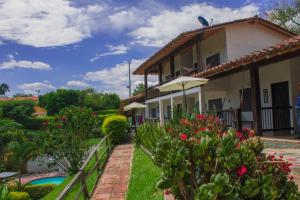 a house with a garden and a swimming pool at Finca Hotel Loma Verde in Quimbaya