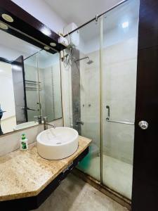 a bathroom with a sink and a glass shower at Hotel Krishana Palace- Malviya Nagar in Gurgaon