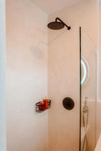 une salle de bain avec une douche avec un panier au mur dans l'établissement Casa Medjango Canggu, à Canggu 20 autres photos