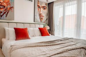 une chambre avec un grand lit avec des oreillers rouges dans l'établissement Casa Medjango Canggu, à Canggu
