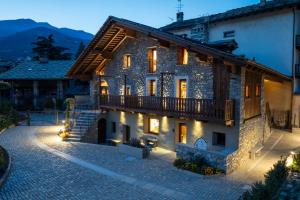 a large stone building with a balcony on a street at Le Grenier d'Antan - Relax Suite in Aosta +64 photos