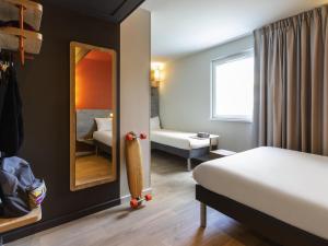 a room with a bedroom with a bed and a mirror at Ibis Budget Strasbourg Centre Republique in Strasbourg