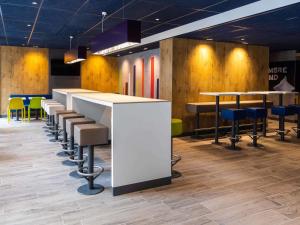 a bar with stools and tables in a room at Ibis Budget Strasbourg Centre Republique in Strasbourg