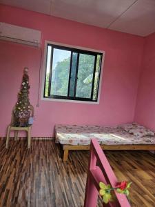 ein rosafarbenes Zimmer mit einer Bank und einem Fenster in der Unterkunft Lola Mamang Resort in General Santos