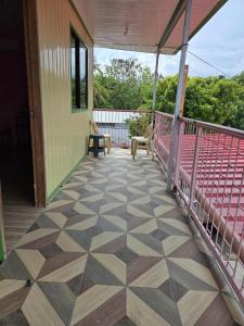 eine überdachte Veranda mit Fliesenboden an einem Haus in der Unterkunft Lola Mamang Resort in General Santos