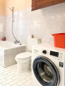 a bathroom with a washing machine and a toilet at Sunny Renovated Ground-Floor Apartment in Neukölln in Berlin