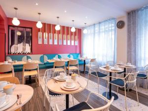 a dining room with tables and chairs in a restaurant at ibis styles Paris Montmartre Batignolles in Paris