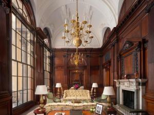 a large room with a bed and a chandelier at Raffles London at The OWO in London