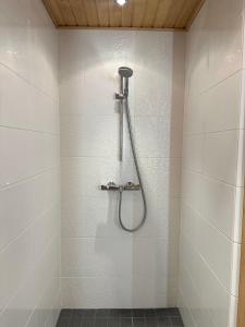 y baño con ducha y azulejos blancos. en Arctic Circle Holiday Homes, en Rovaniemi