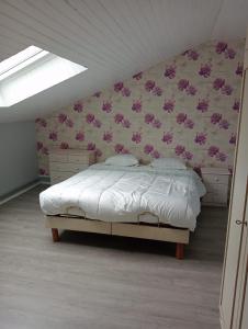 a bedroom with a bed with pink flowers on the wall at Coriandre La Tisanerie 1 room apartment et lits d appoint in Condé-sur-lʼEscaut