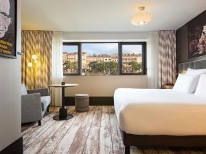 a hotel room with a bed and a window at Hotel Les Capitouls Toulouse Centre - Handwritten Collection in Toulouse