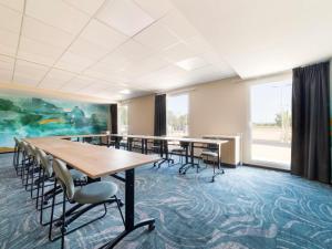 una sala de conferencias con mesas, sillas y una pintura en Ibis Styles Miramas, en Miramas 93 fotos más