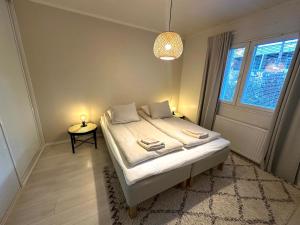 Un dormitorio con una cama con una lámpara y una ventana. en Arctic Circle Holiday Homes, en Rovaniemi