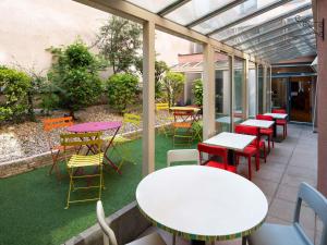 a patio with tables and colorful chairs and tables at Adagio Access Lyon Centre Université in Lyon