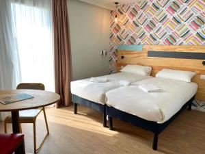 a hotel room with a bed and a table at greet hotel Castets Coeur des Landes in Castets