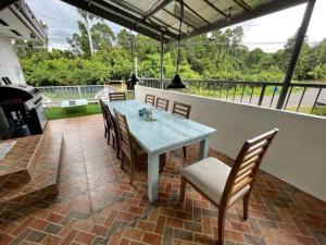 a patio with a table and chairs and a grill at A Pet Friendly Subic Bay Vacation Home in Olongapo