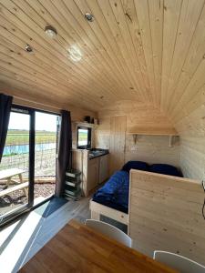 a bedroom in a tiny house with a bed and a table at Aqua Lodge in Petten