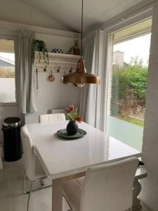 a white table and chairs in a kitchen with a window at Bungalow 001 in Petten