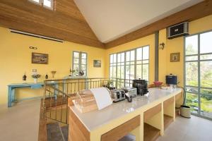 a large room with yellow walls and a kitchen with a counter at Doi Tung View Resort in Mae Sai