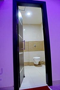 una puerta que conduce a un baño con aseo en Hotel d c vilas, en Agra