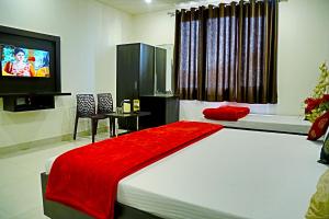 Un dormitorio con una cama grande con una manta roja. en Hotel d c vilas, en Agra