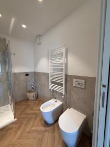 a bathroom with a white toilet and a sink at Appartamento Verde in Pordenone