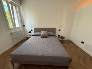a bedroom with a large bed in a white room at Appartamento Verde in Pordenone